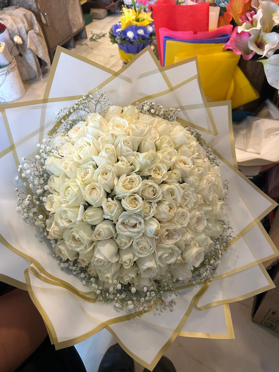 50 white roses bouquet with baby's breath and white-and-gold wrapping for delivery in Ghaziabad