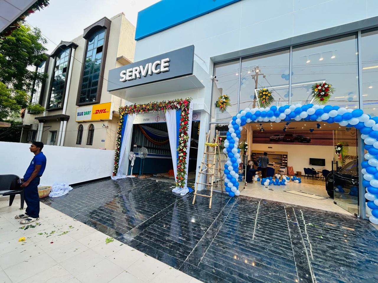 Car showroom service entrance decorated with fresh flowers and a blue white balloon arch in Noida