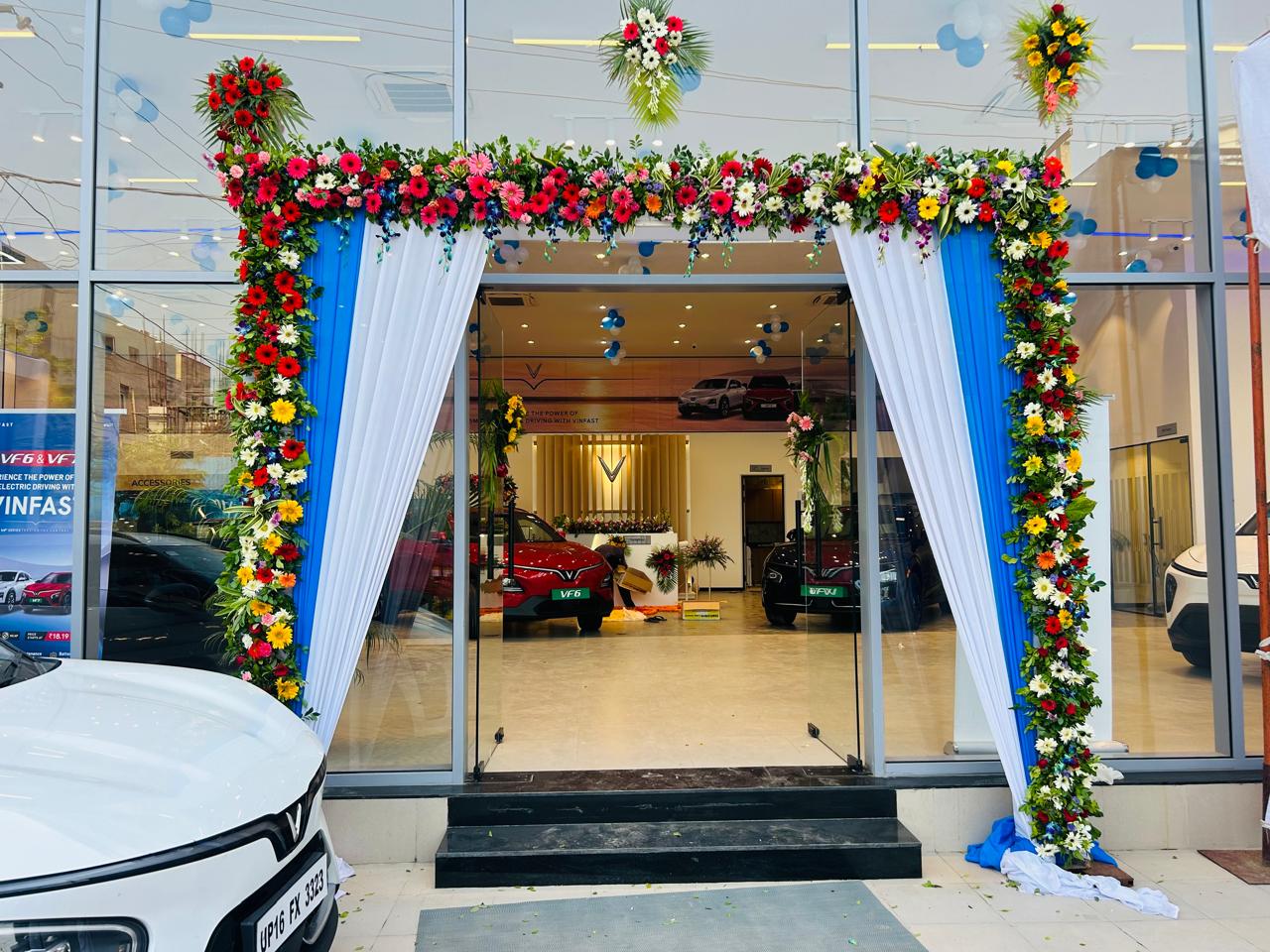 Multicolour fresh flower frame and blue white fabric at a car showroom main entrance