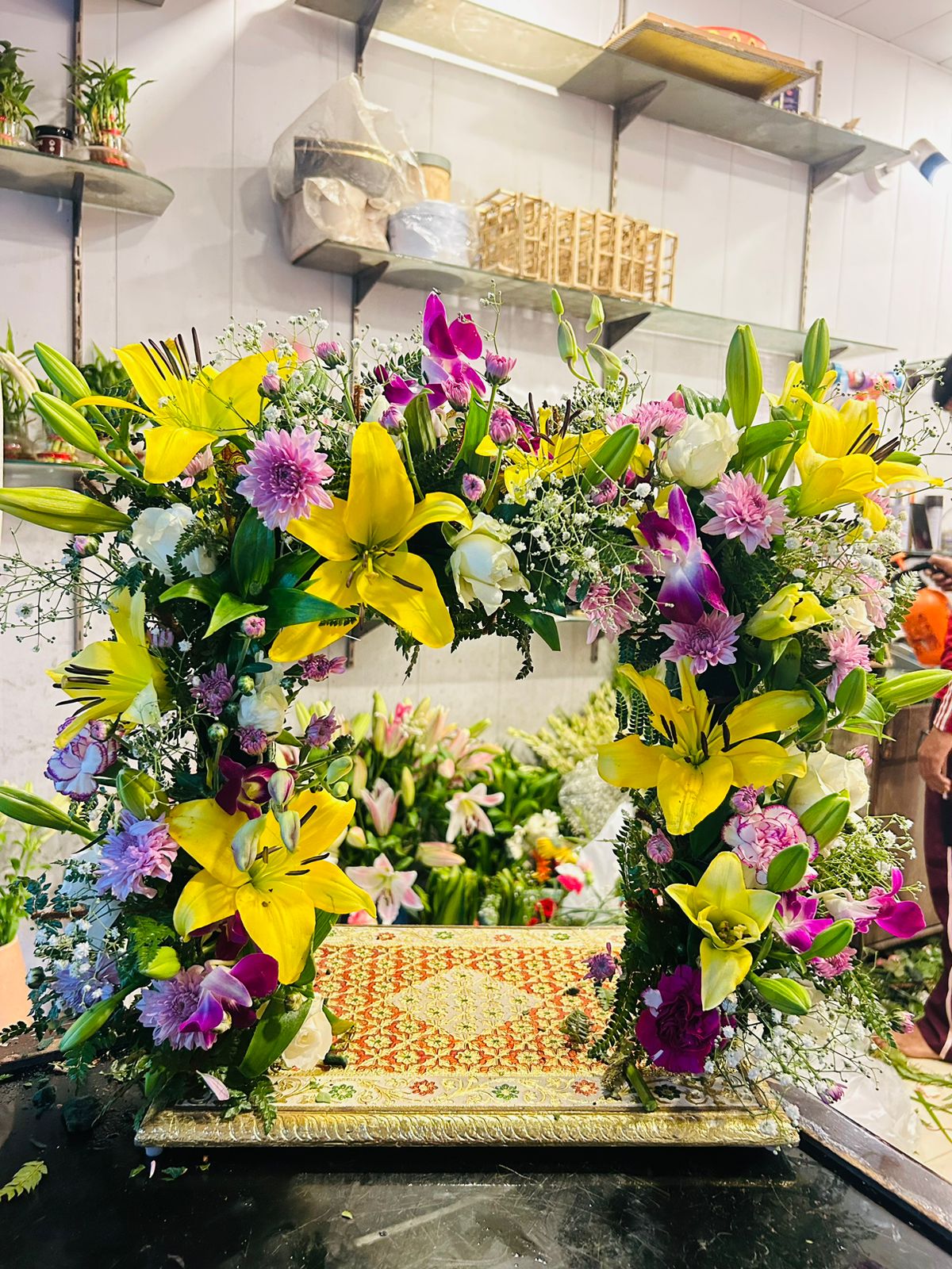 Small Krishna Janmashtami jhula decorated with yellow lilies, orchids and fresh flowers in Nehru Nagar Ghaziabad